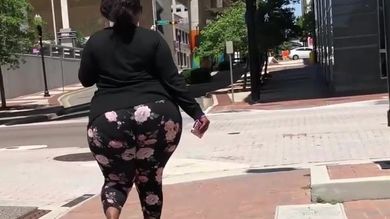 Парень на улице снимает скрытой камерой большую жопу жирной негритянки в лосинах